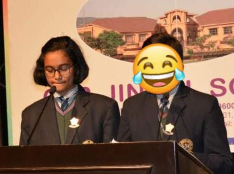 Akshara speaking at a school podium in uniform