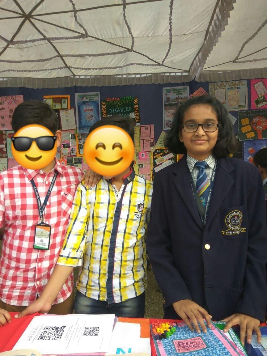 Akshara standing with classmates at a school display